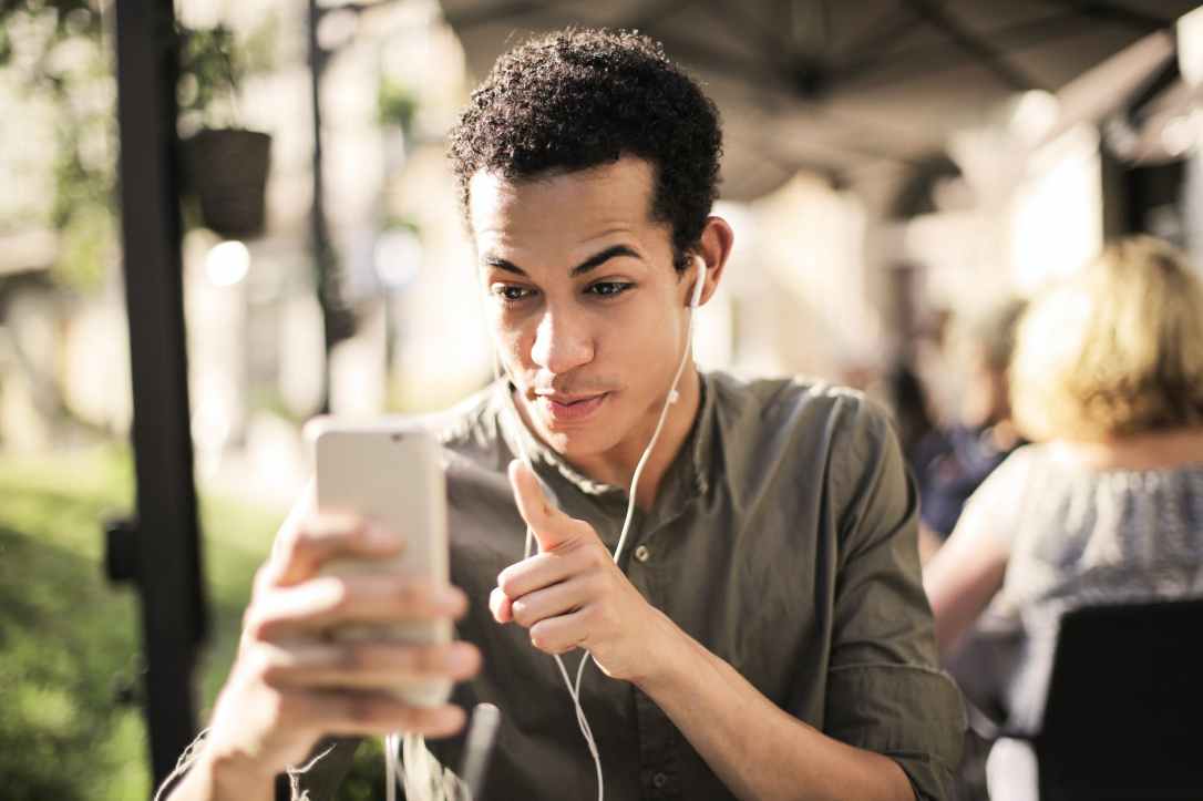 selective focus photo of man in brown button up shirt holding talking on the phone